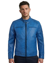 Man wearing a blue leather jacket on a gray background