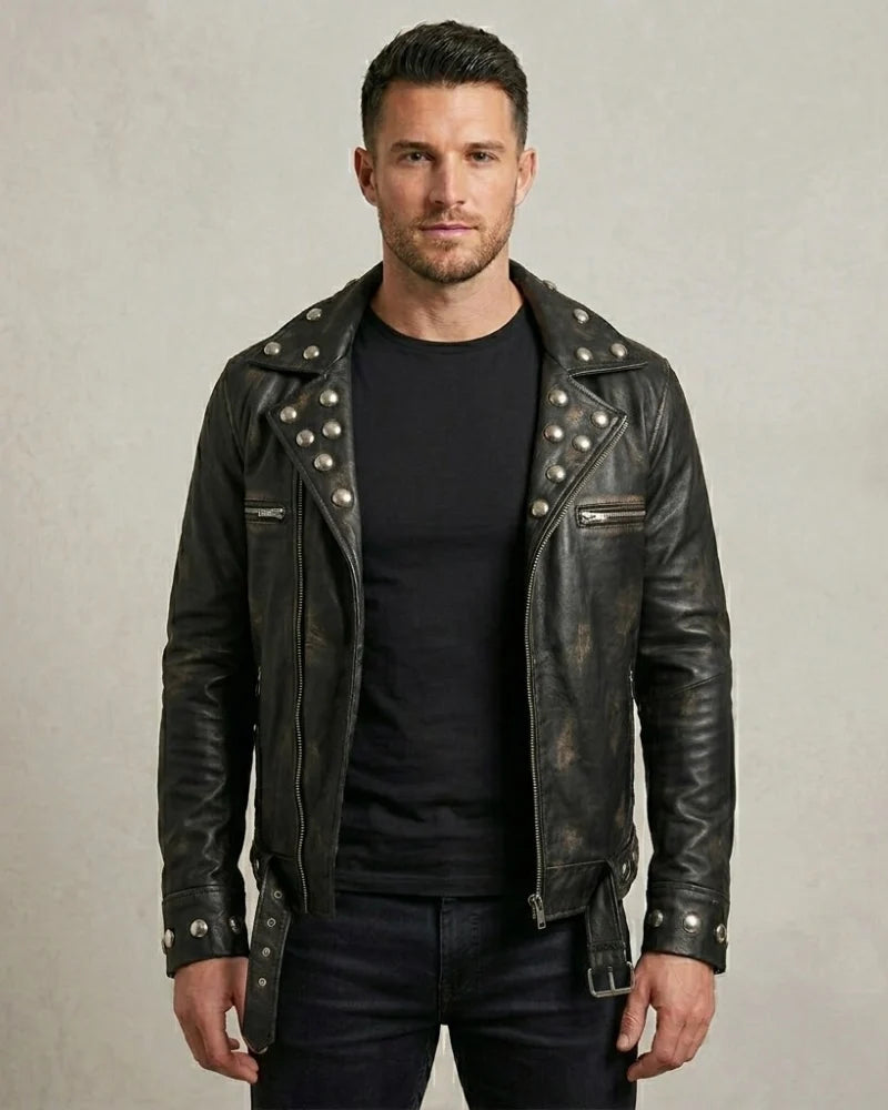 Man wearing a black leather jacket with studs on a plain background