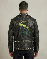 Man wearing a black leather jacket with a snake design on the back against a neutral background