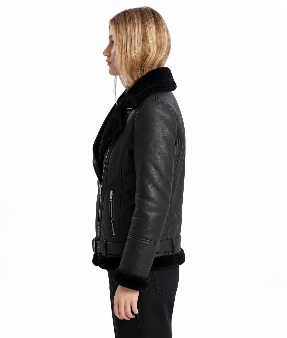 A woman shown in side profile wearing a black leather aviator-style jacket with black shearling lining on the collar, cuffs, and hem, paired with black pants, against a plain white background.