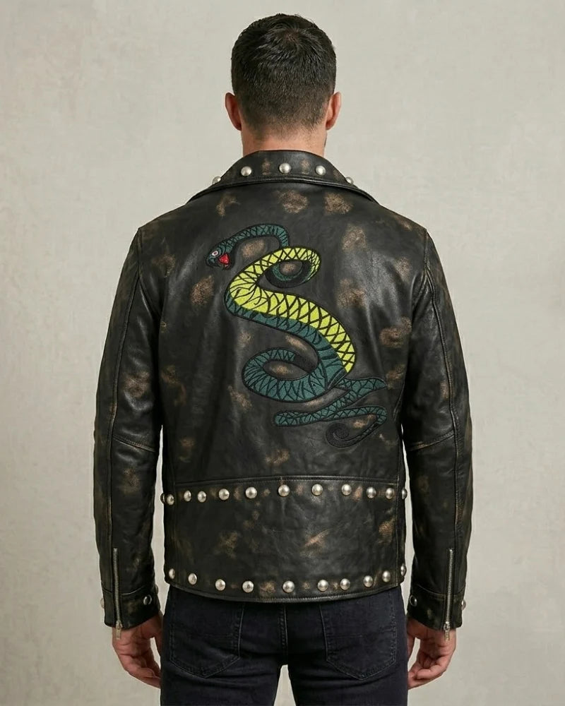 Man wearing a black leather jacket with a snake design on the back against a neutral background