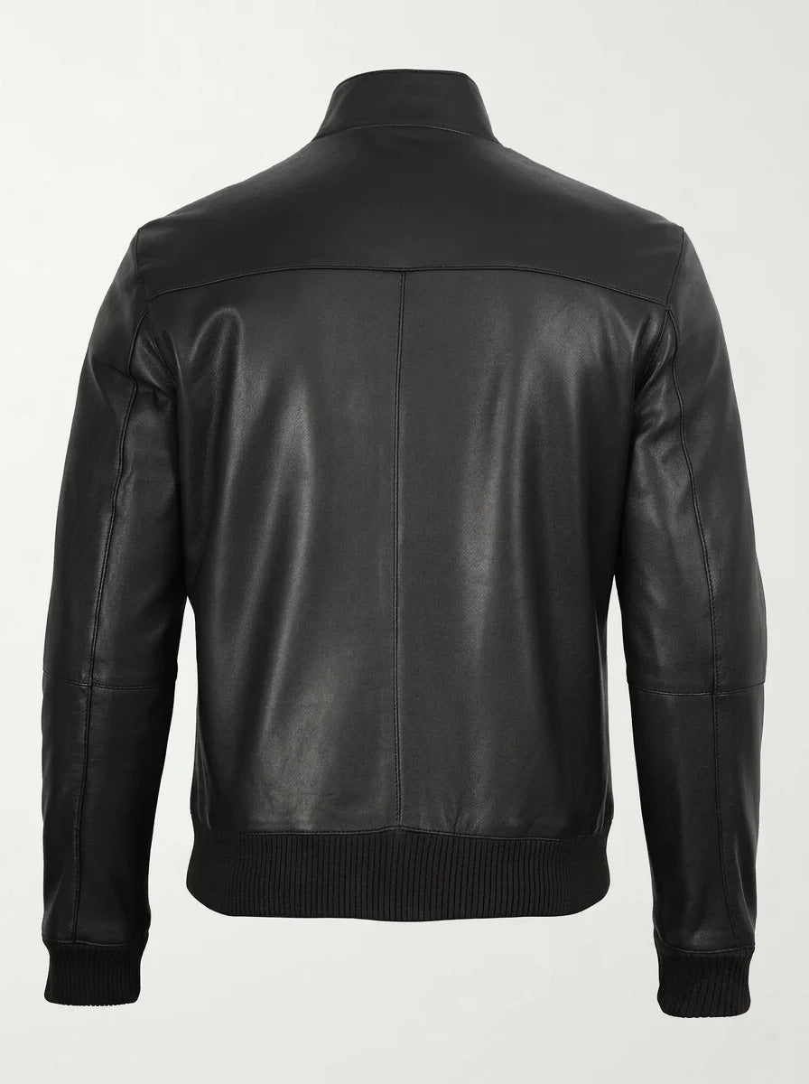 Back view of a black leather bomber jacket on a male model, showing the shoulder yoke, center seam and ribbed waistband.