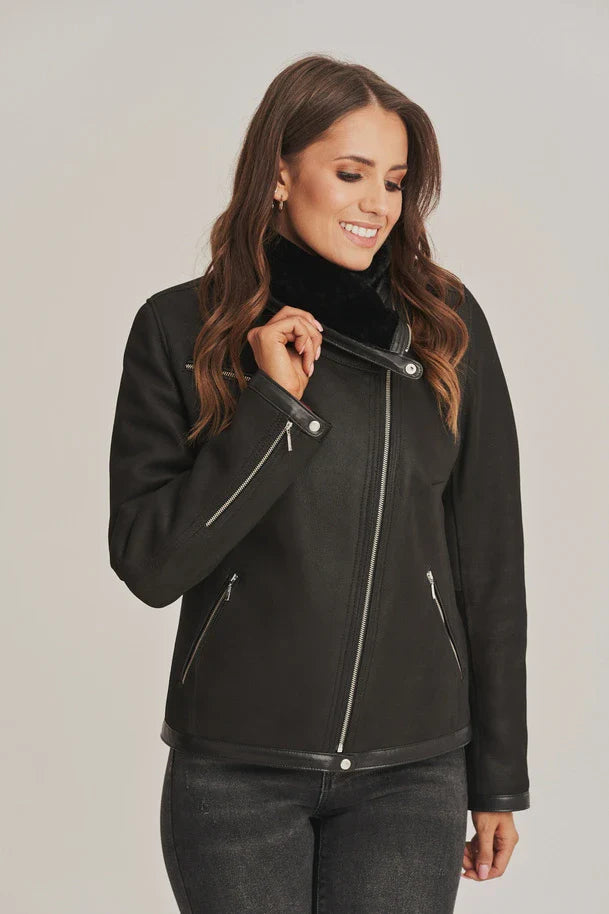 Woman wearing a black jacket with a plain background