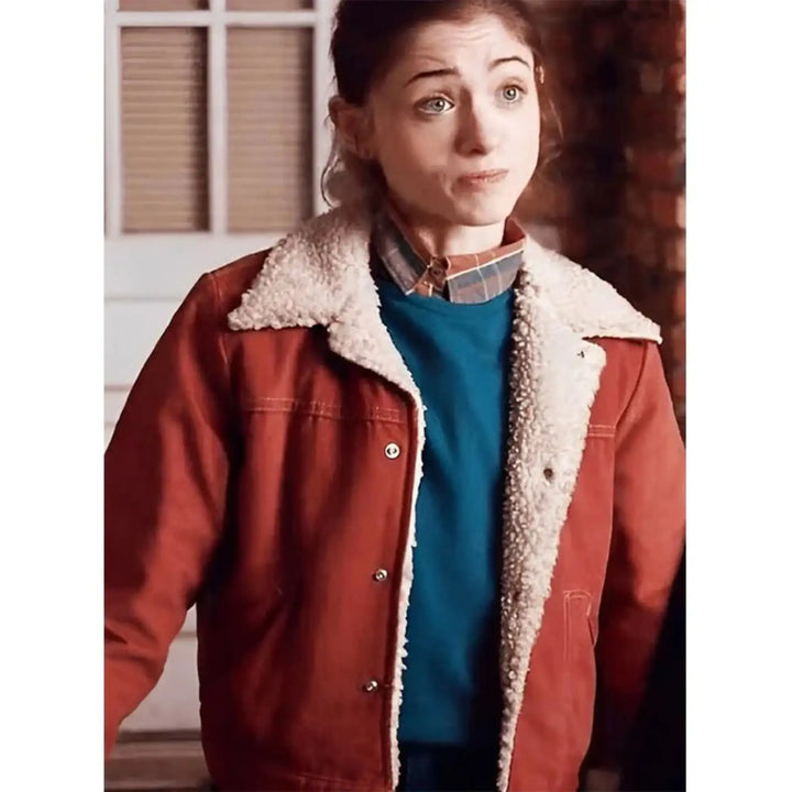 Person wearing a red jacket with white fur lining indoors