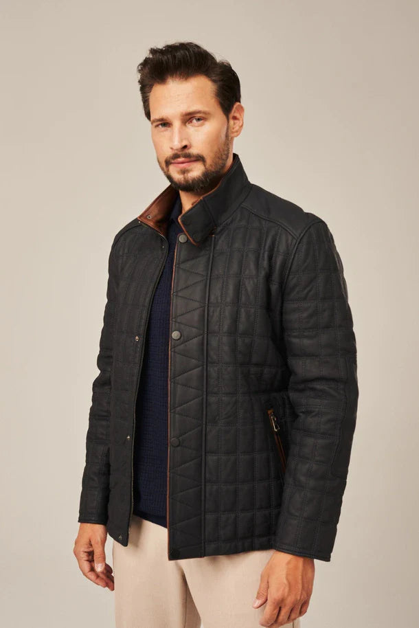 Man wearing a dark quilted jacket with a plain background