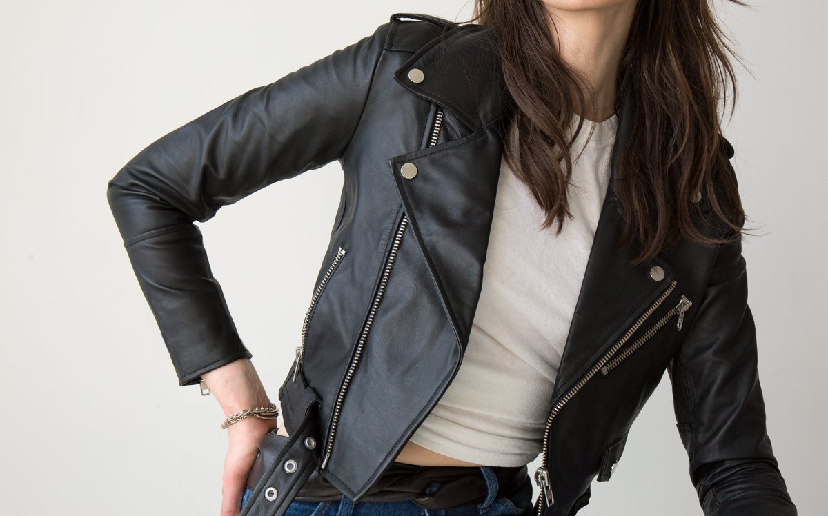 Person wearing a black leather jacket on a plain background