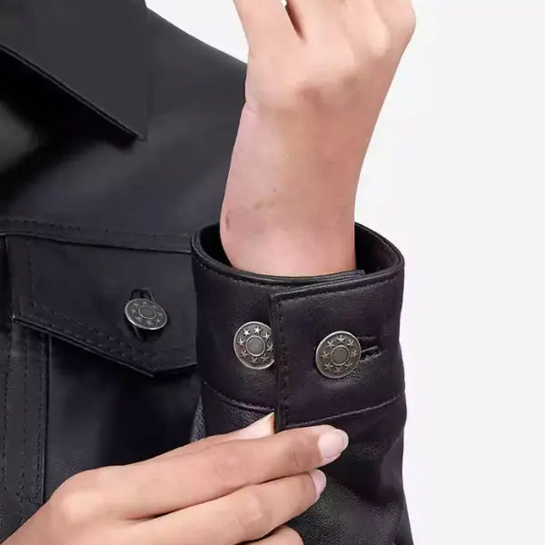 Close-up of a person wearing a black jacket with decorative buttons on a white background