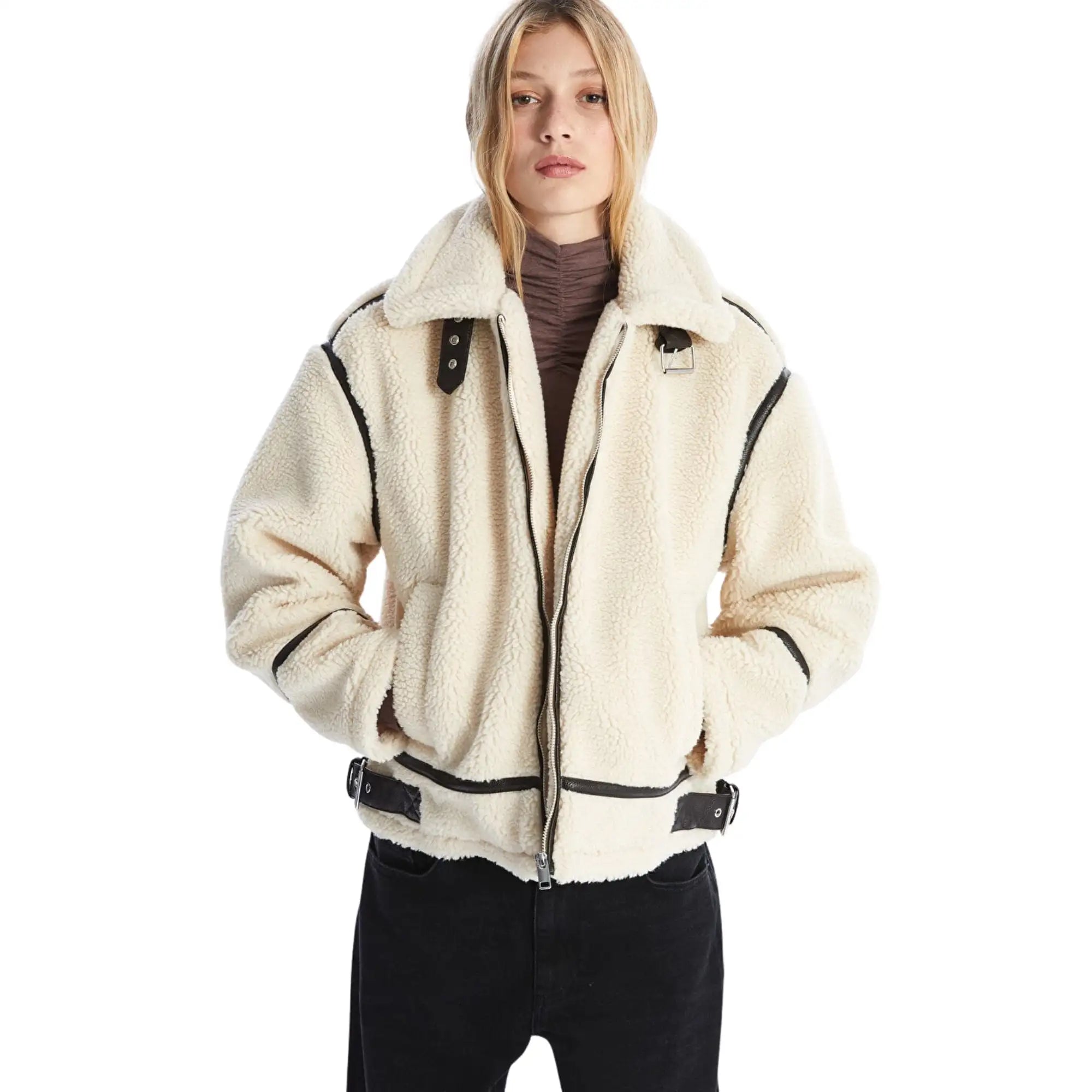 Person wearing a cream-colored fleece jacket with black accents on a white background