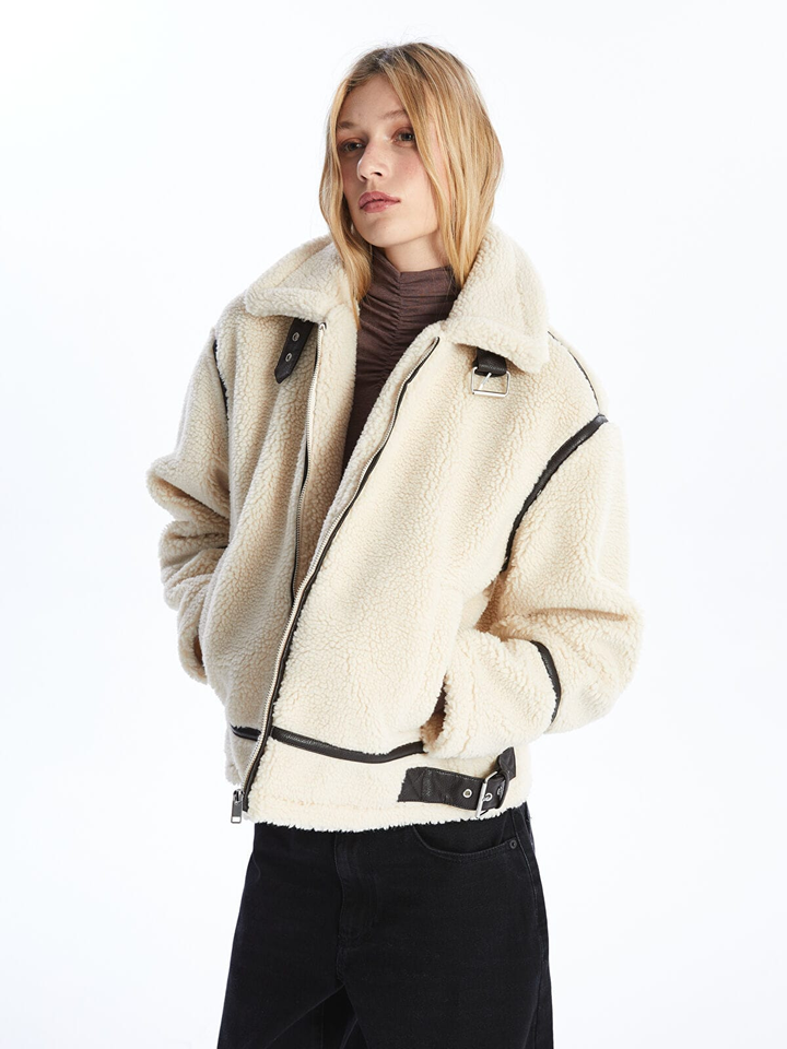 Woman wearing a beige sherpa jacket on a white background