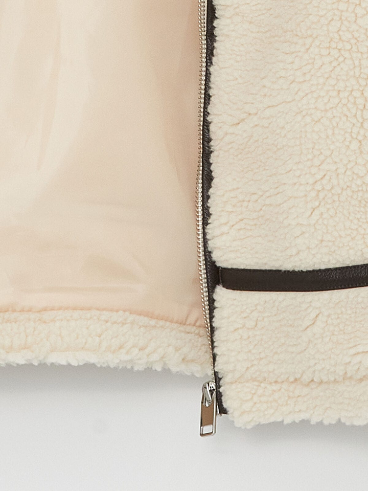Close-up of a beige fleece jacket with a zipper on a white background